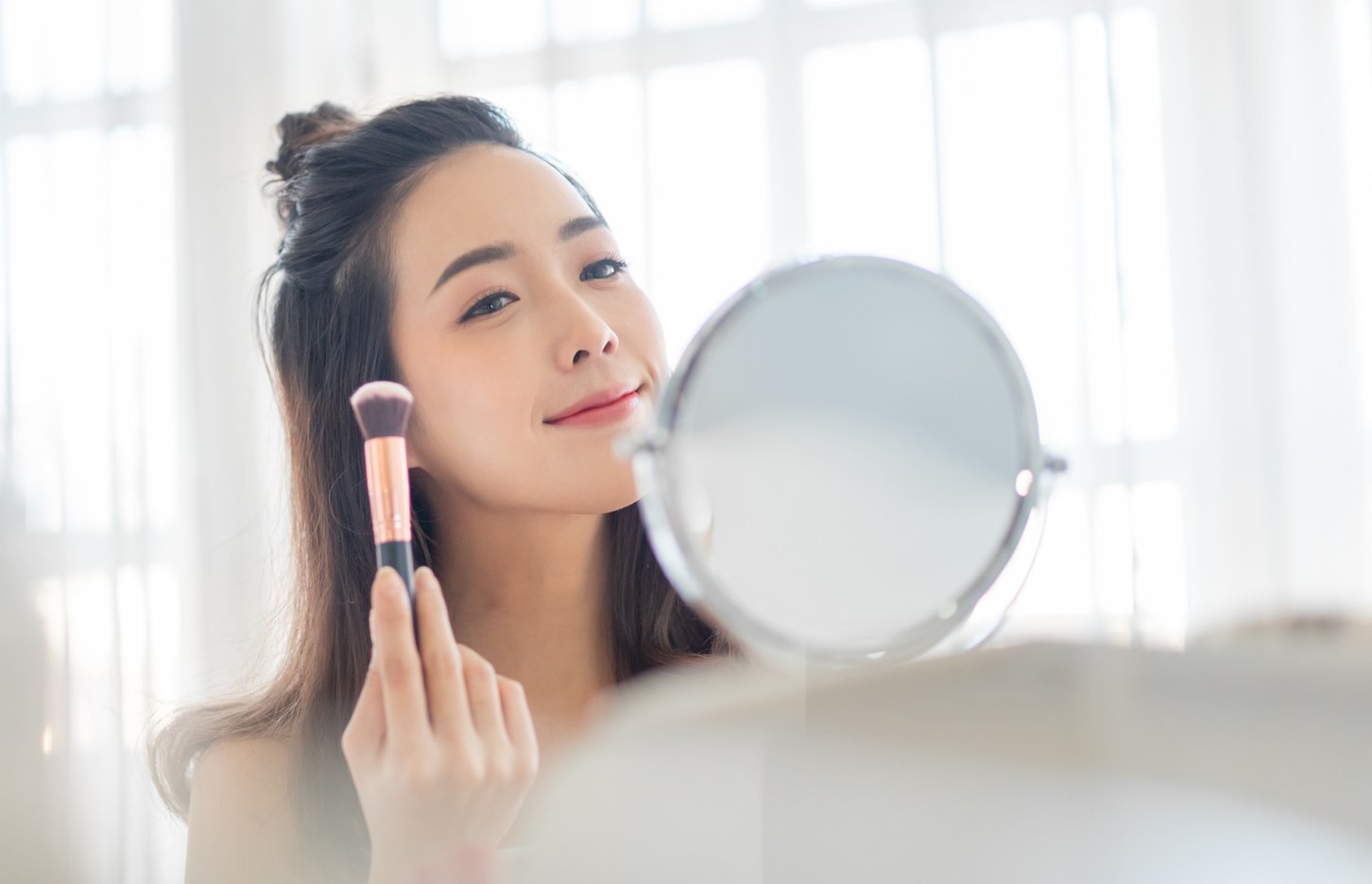 Asian Korean Female model using makeup brush